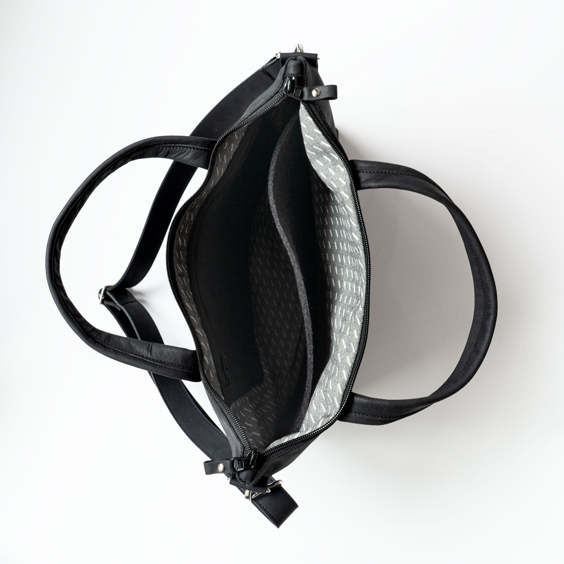 Innenansicht der Umhängetasche ANA in Kohle mit Futterstoff, Laptopfach und kleinem Reißverschlussfach innen