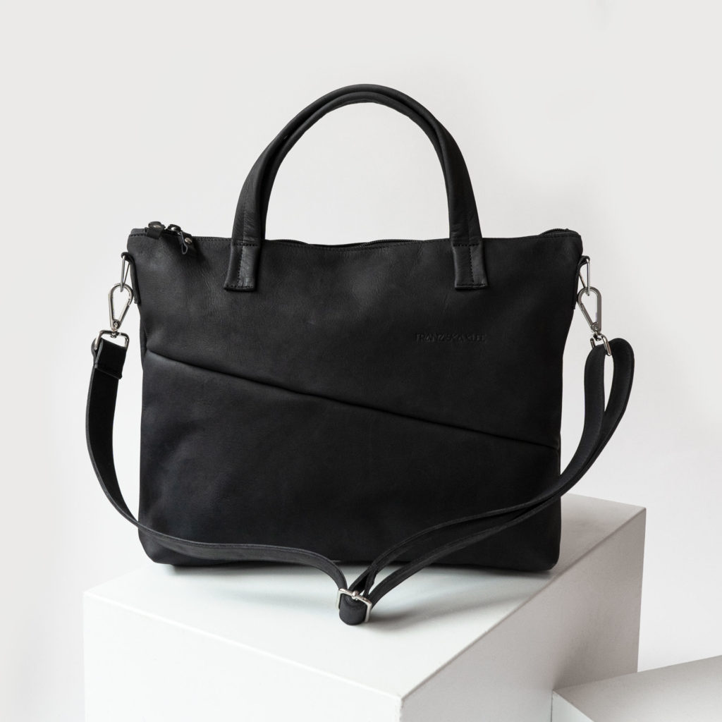 Vorderseite der Umhängetasche ANA aus nachhaltigem Naturleder in Kohle mit verstellbarem Träger und dezenter Logoprägung