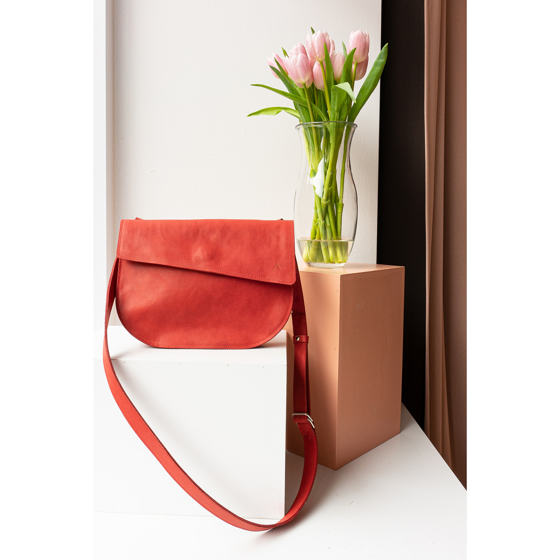 Minimalistische Umhängetasche BEA von vorn in Schaufenster mit Blumenstrauß