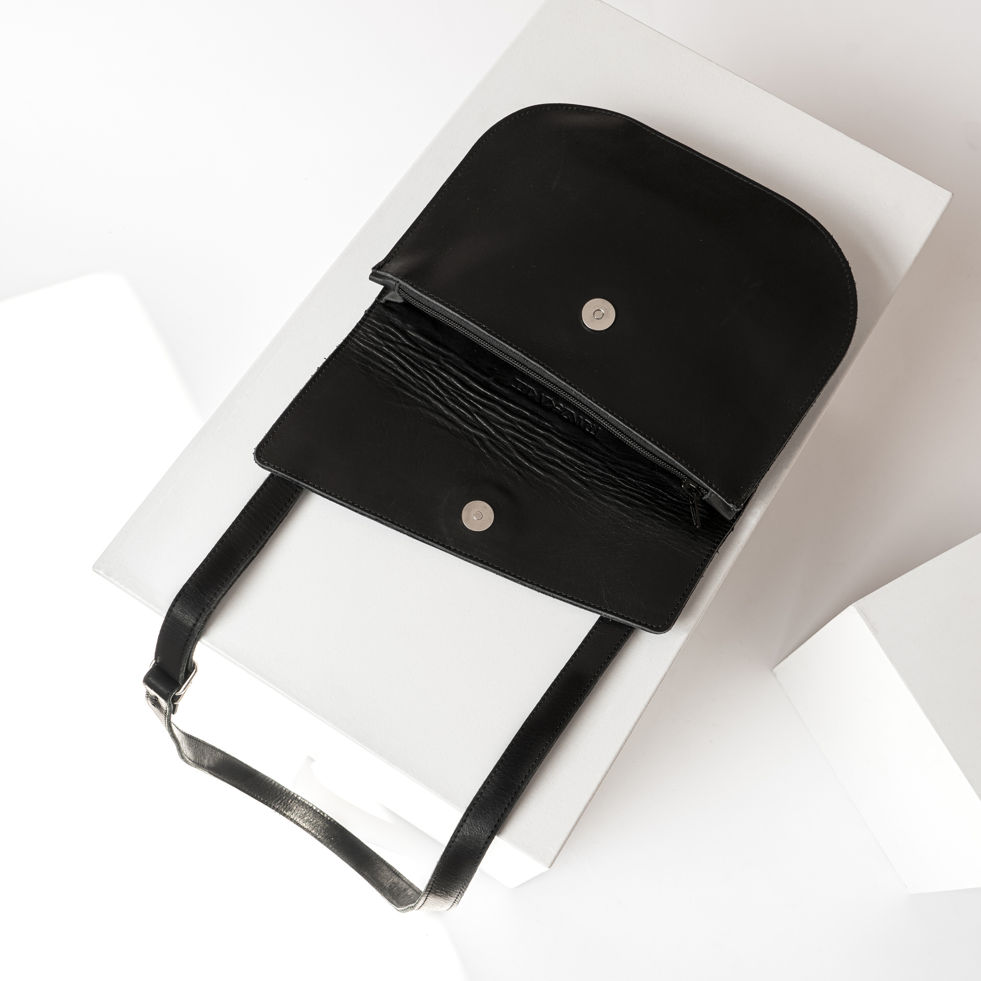 Umhängetasche BEA mit Reißverschluss und Magnetverschluss liegend aufgeklappt aus Naturleder in Schwarz geölt