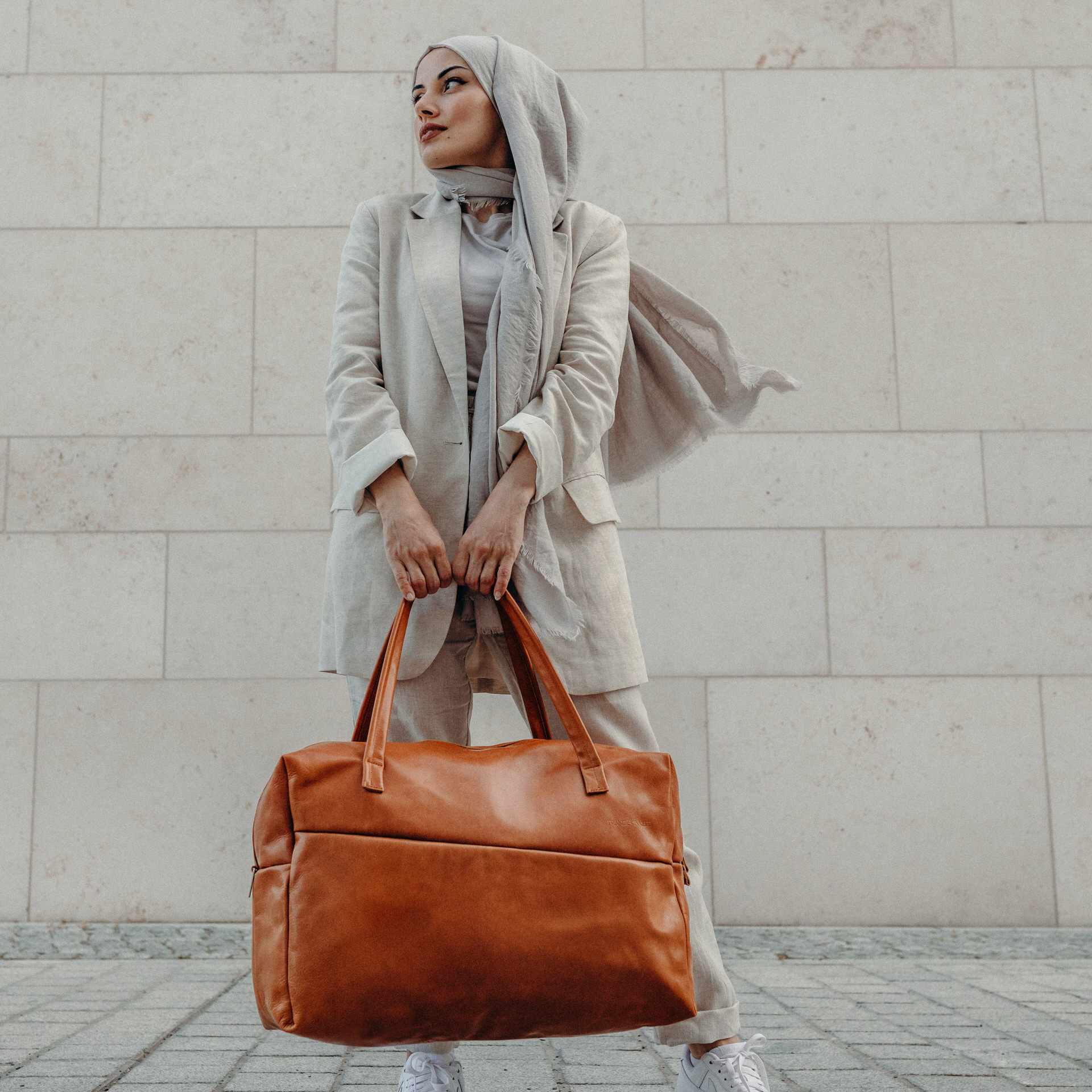 Model mit Weekender Reisetasche RIO mit Henkeln aus cognacfarbenem geölten Naturleder