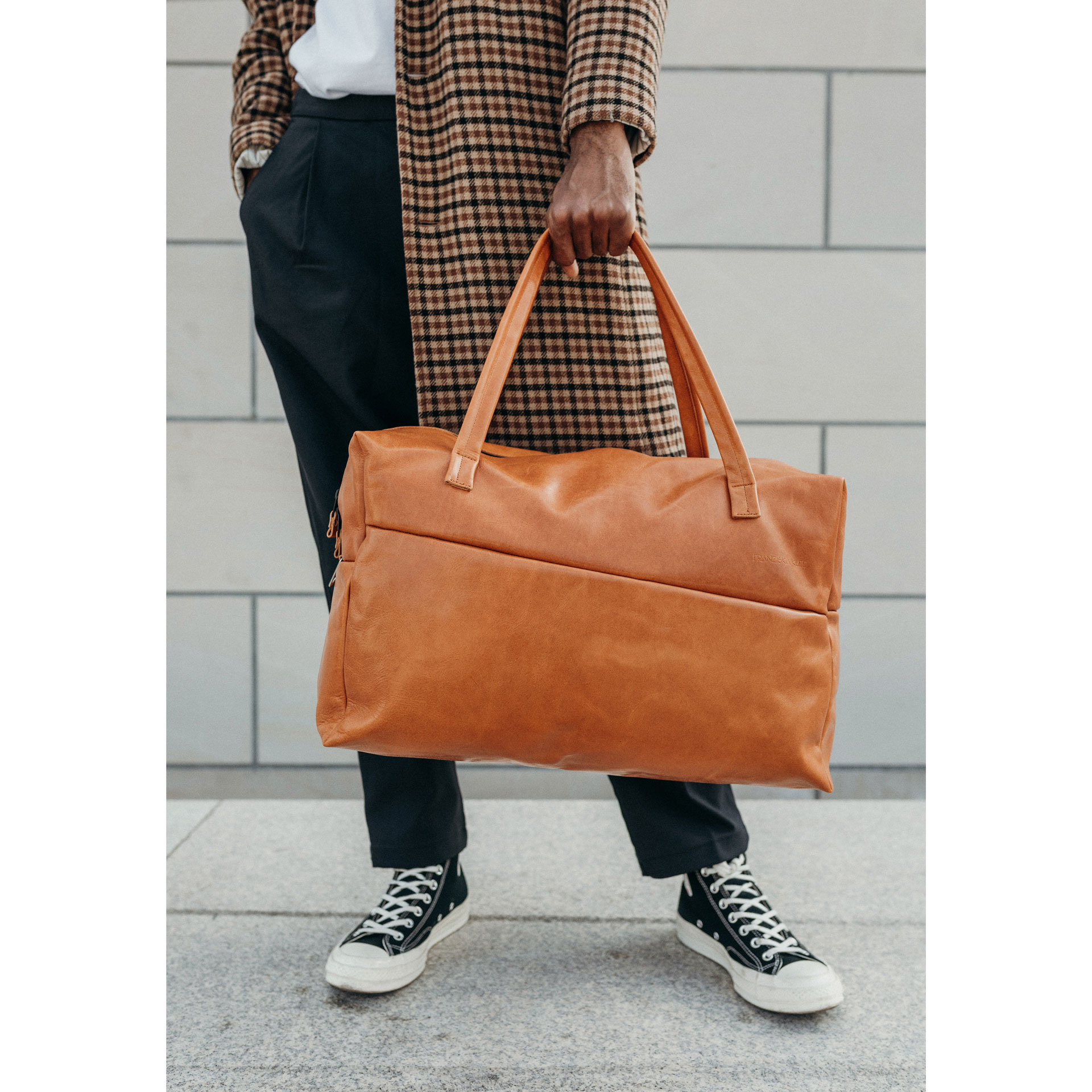 Model mit Weekender Reisetasche RIO mit Henkeln aus cognacfarbenem geölten Naturleder