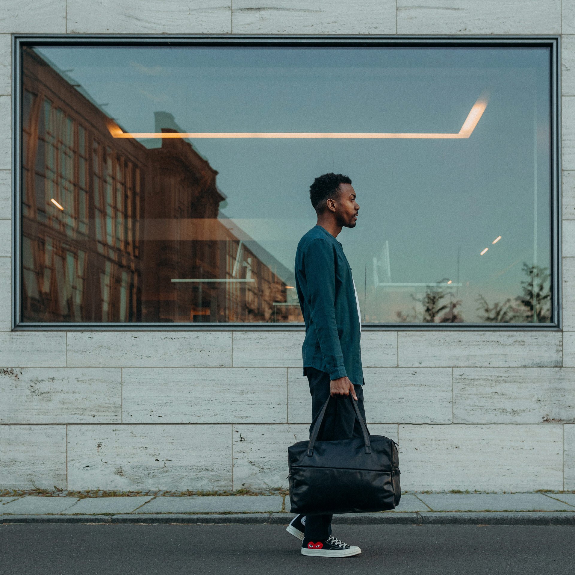 Model mit Weekender Reisetasche RIO mit Henkeln aus schwarzem geölten Naturleder