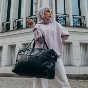 Model mit Weekender Reisetasche RIO mit Henkeln aus schwarzem geölten Naturleder
