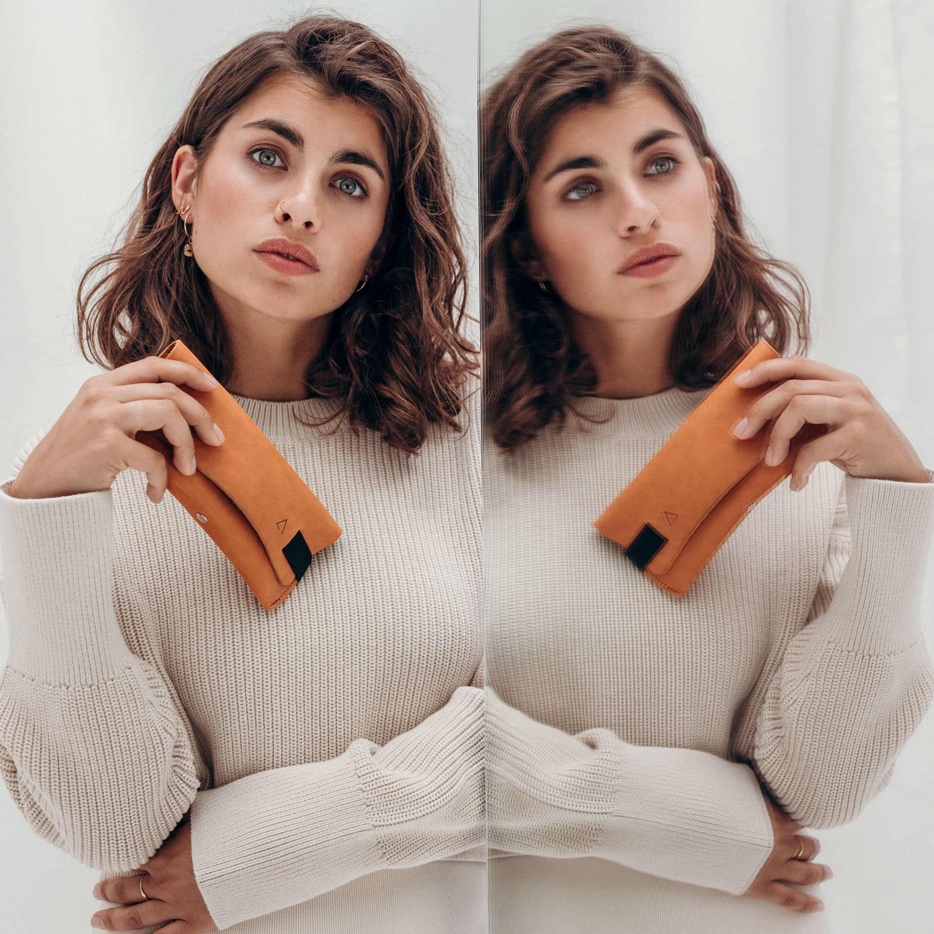 Unser Model hält das Brillenetui LUK vor einem Spiegel in der Hand.