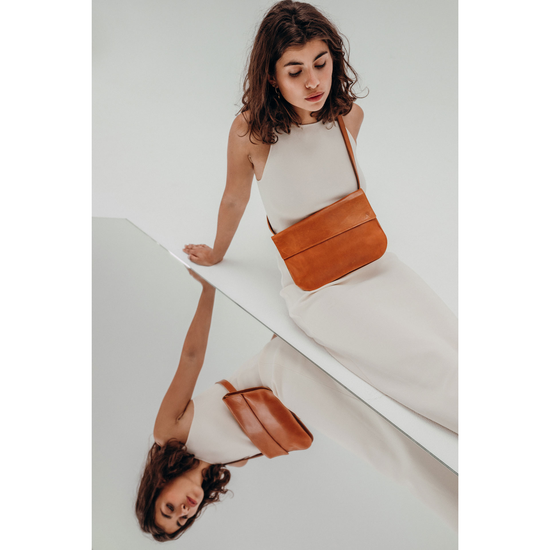 Model mit Crossbody Bag Tea Large aus cognacfarbenem geölten Naturleder