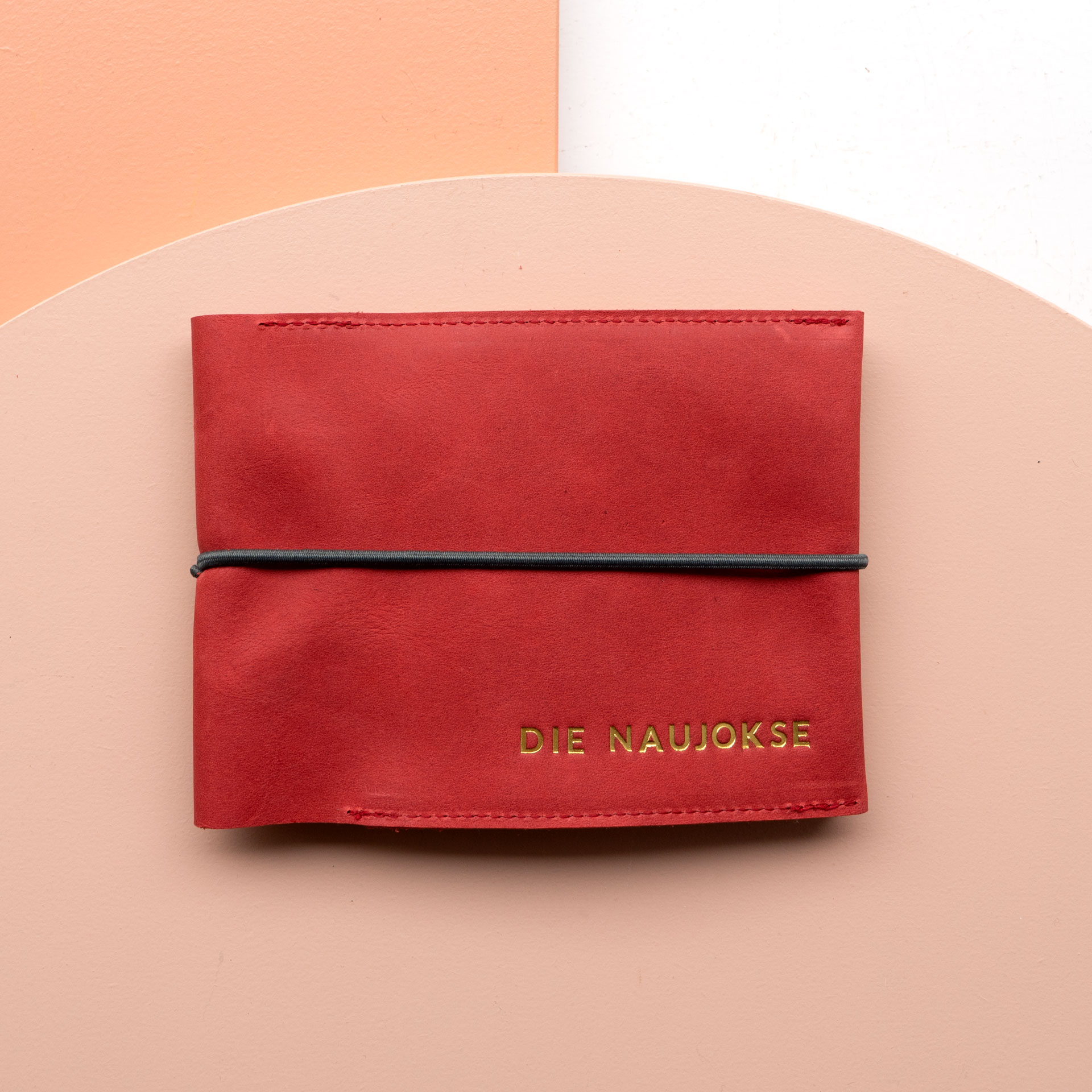 Familienreisepasshülle EVE aus Naturleder in Rot mit schwarzem Verschlussband und individueller Prägung in Gold