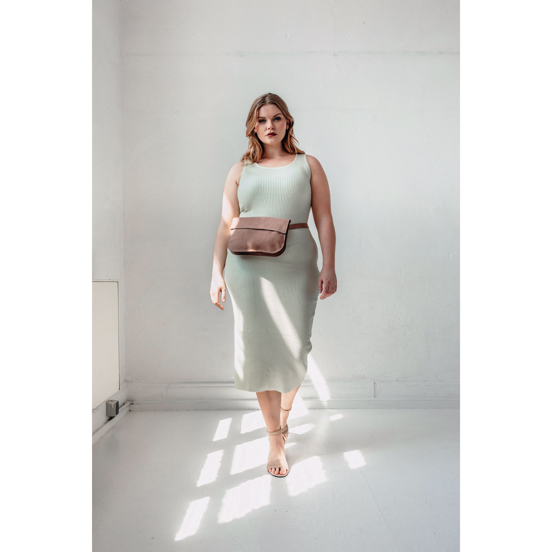 Model trägt Crossbody Bag TEA Large in der Farbe Hellbraun um die Hüfte.