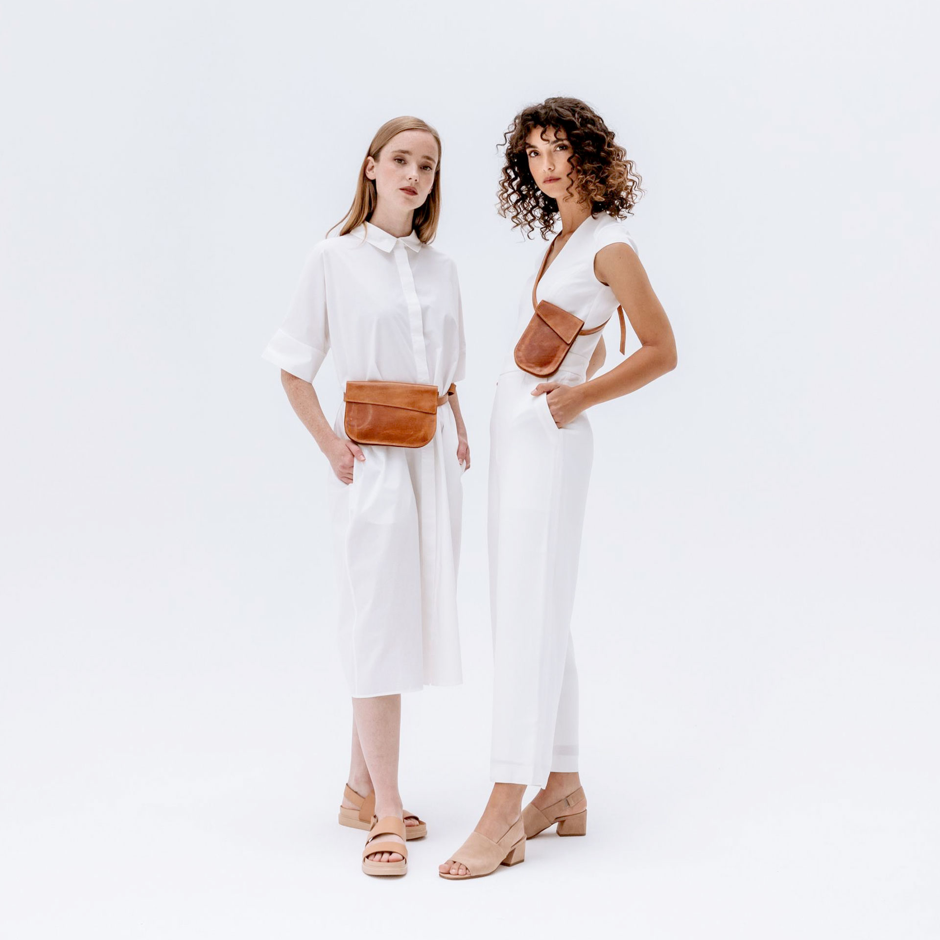 Model mit Crossbody Bag TEA in Cognac geölt steht neben Model mit Brustbeutel Handytasche IRA in Cognac geölt