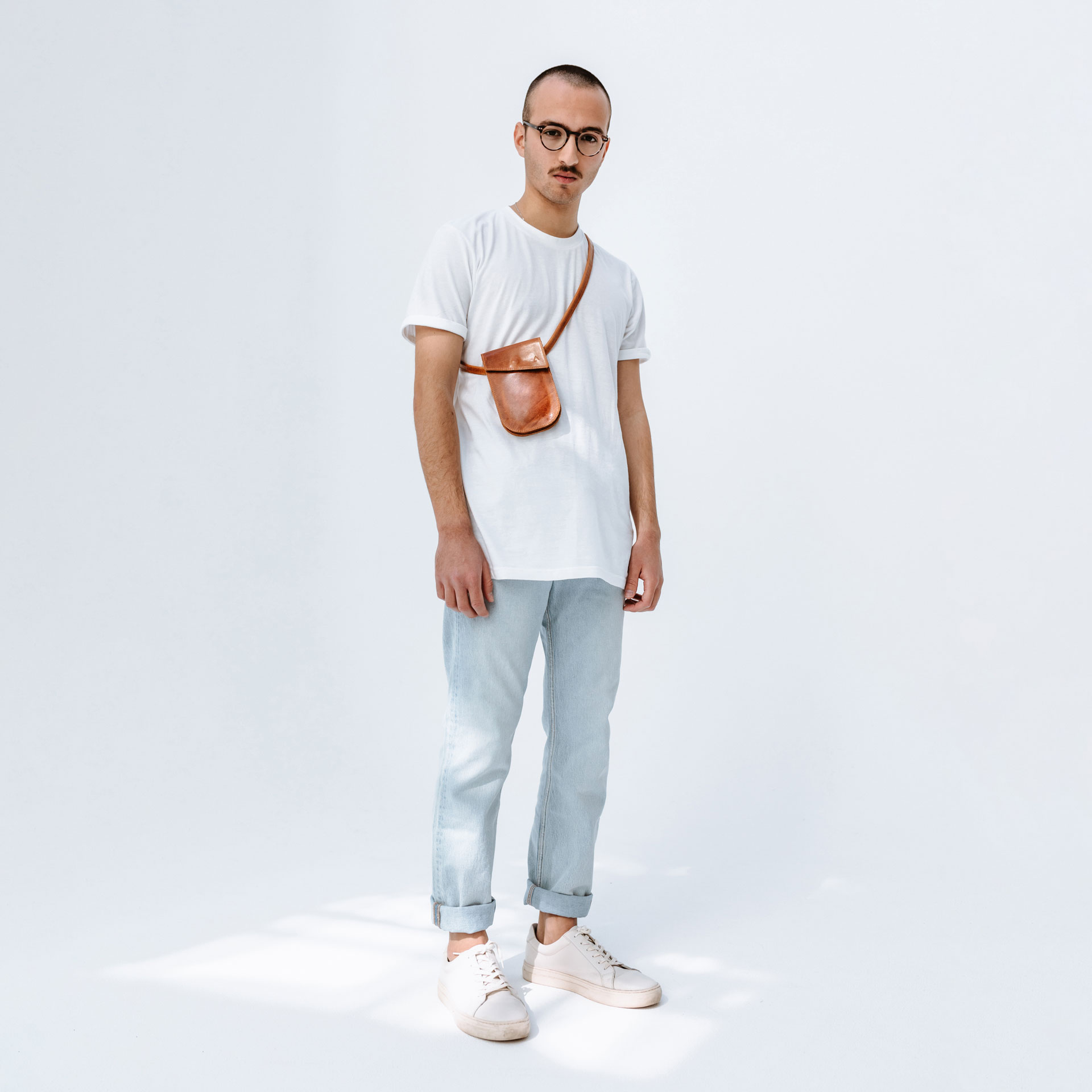 Männliches Model trägt Brustbeutel IRA in der Farbe Cognac geölt aus nachhaltigem Ökoleder crossbody.