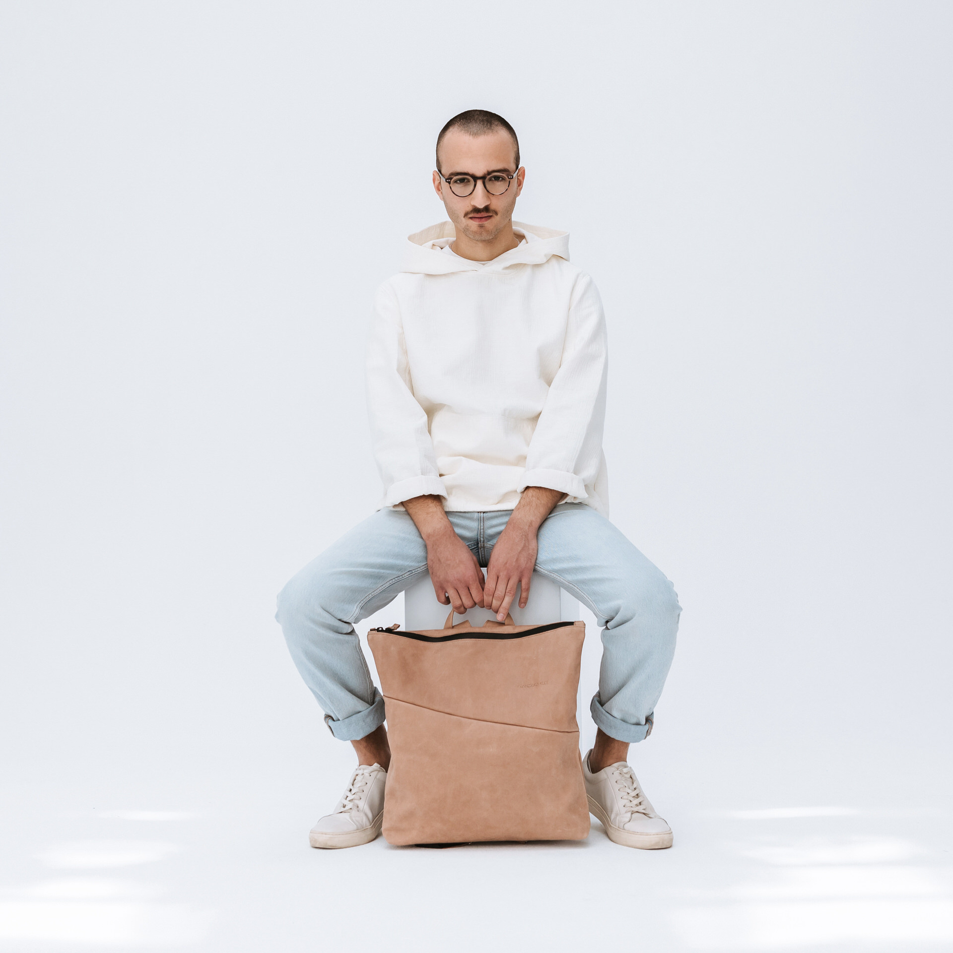 männliches Model mit Wickelrucksack Lin aus hellbraunem Naturleder