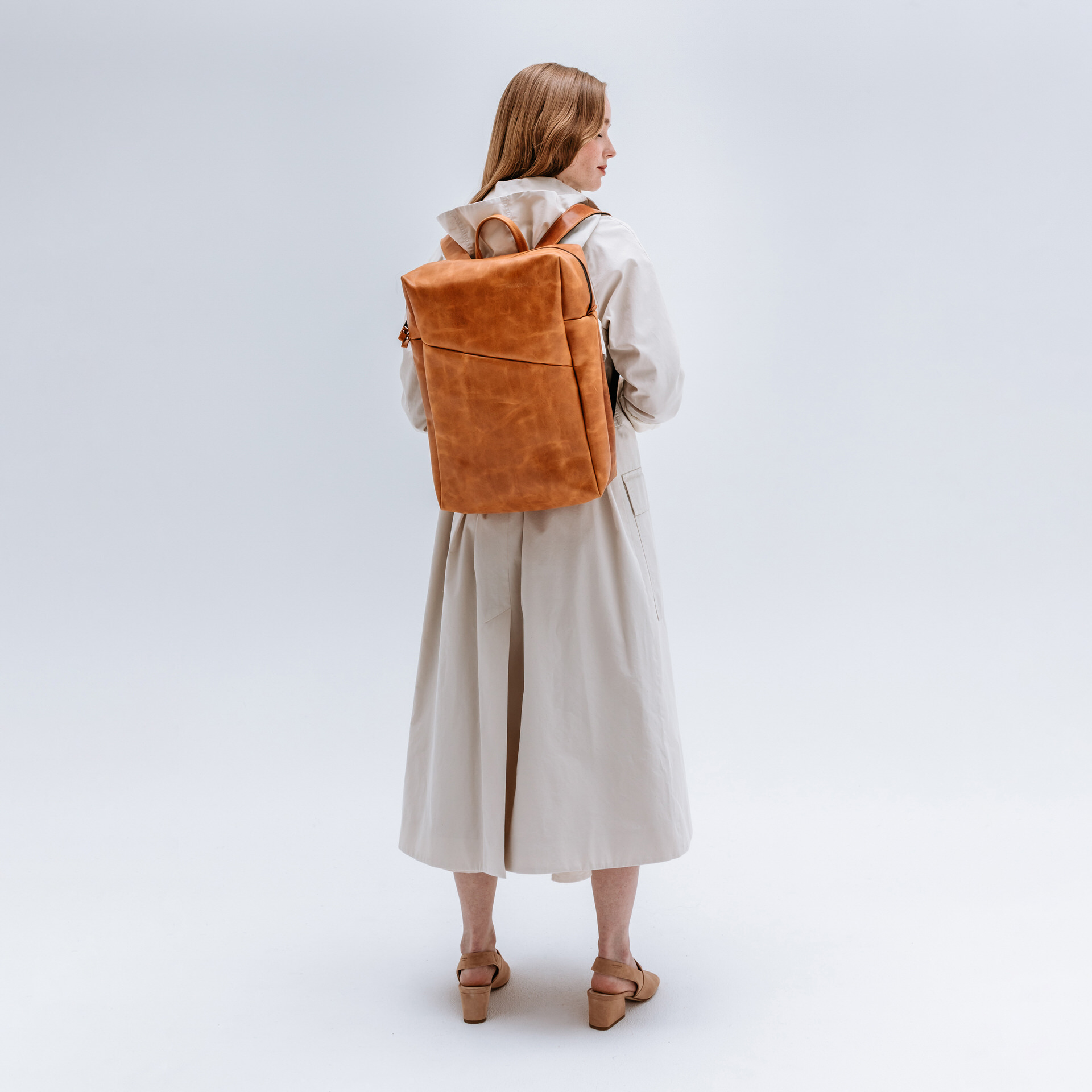 Model mit Rucksack Neo Large aus cognac geöltem Naturleder