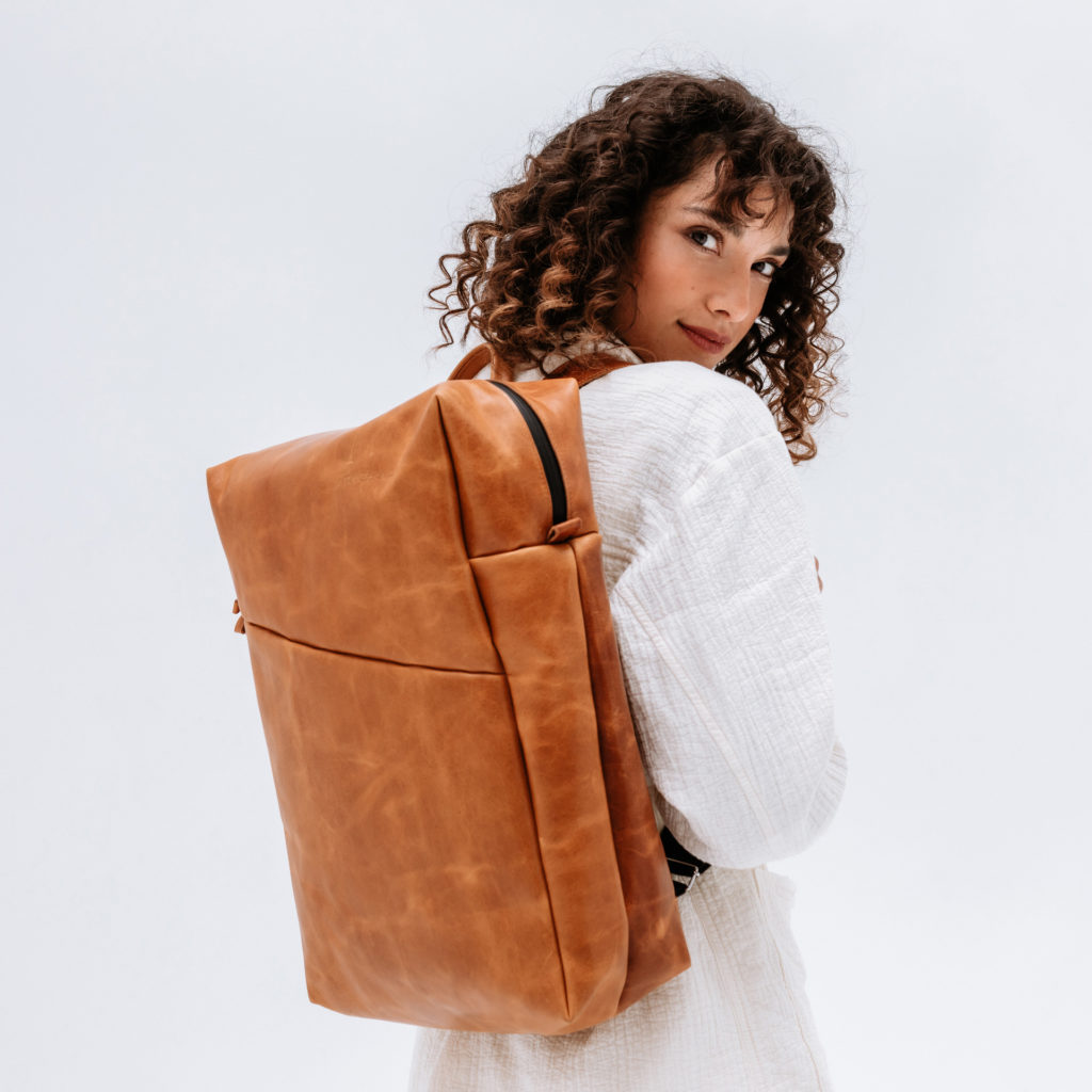 Model mit Rucksack Neo Large aus cognac geöltem Naturleder