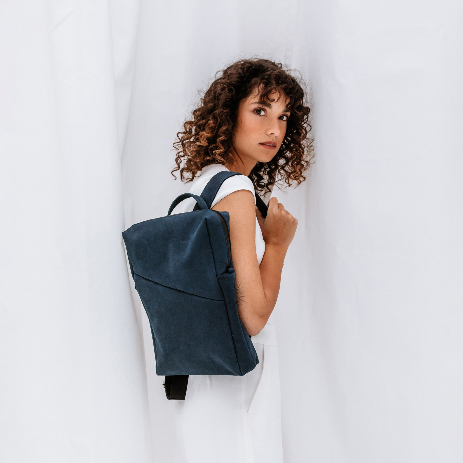 Model mit Rucksack Neo small aus dunkelblauem Naturleder
