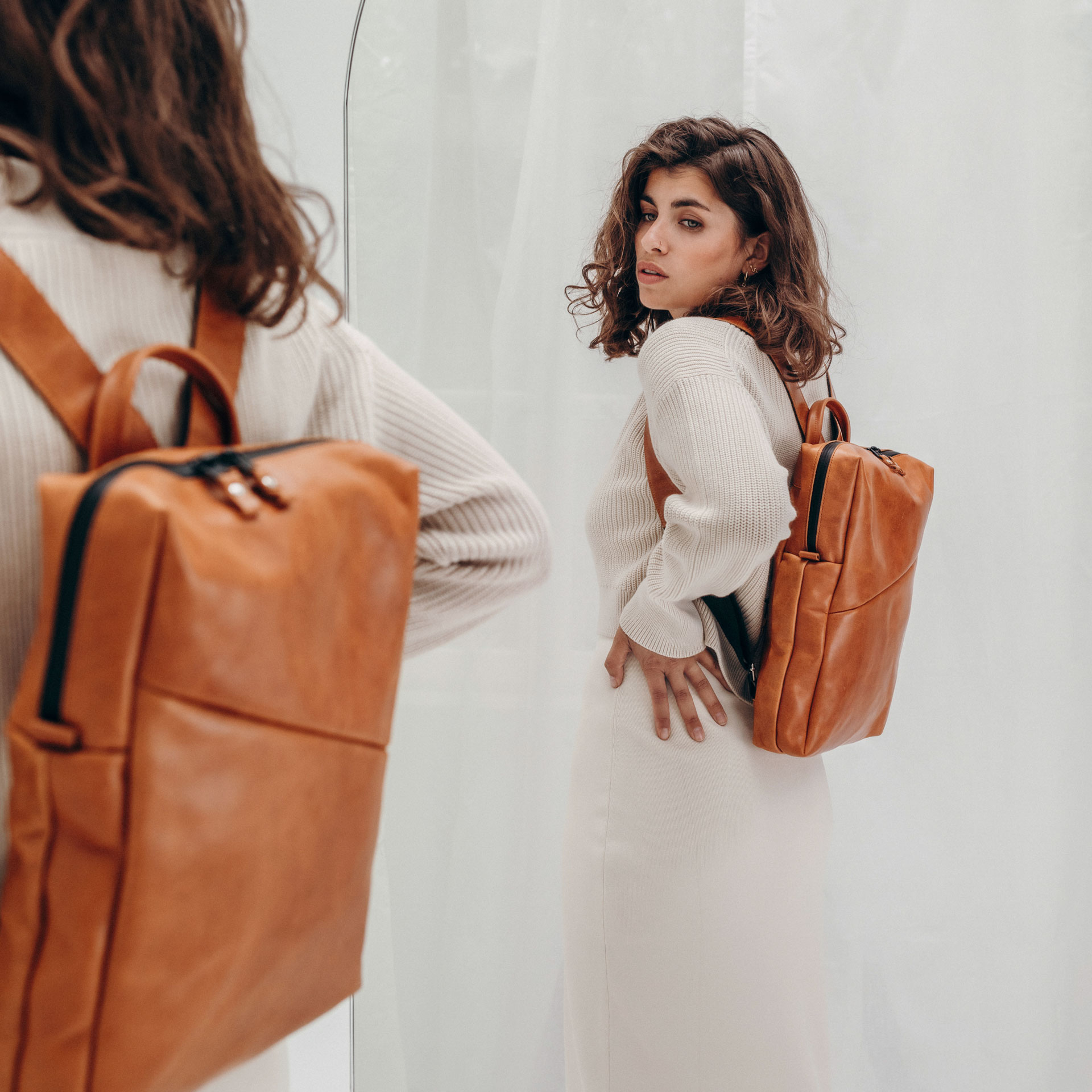 Model mit Rucksack Neo small aus cognac geöltem Naturleder