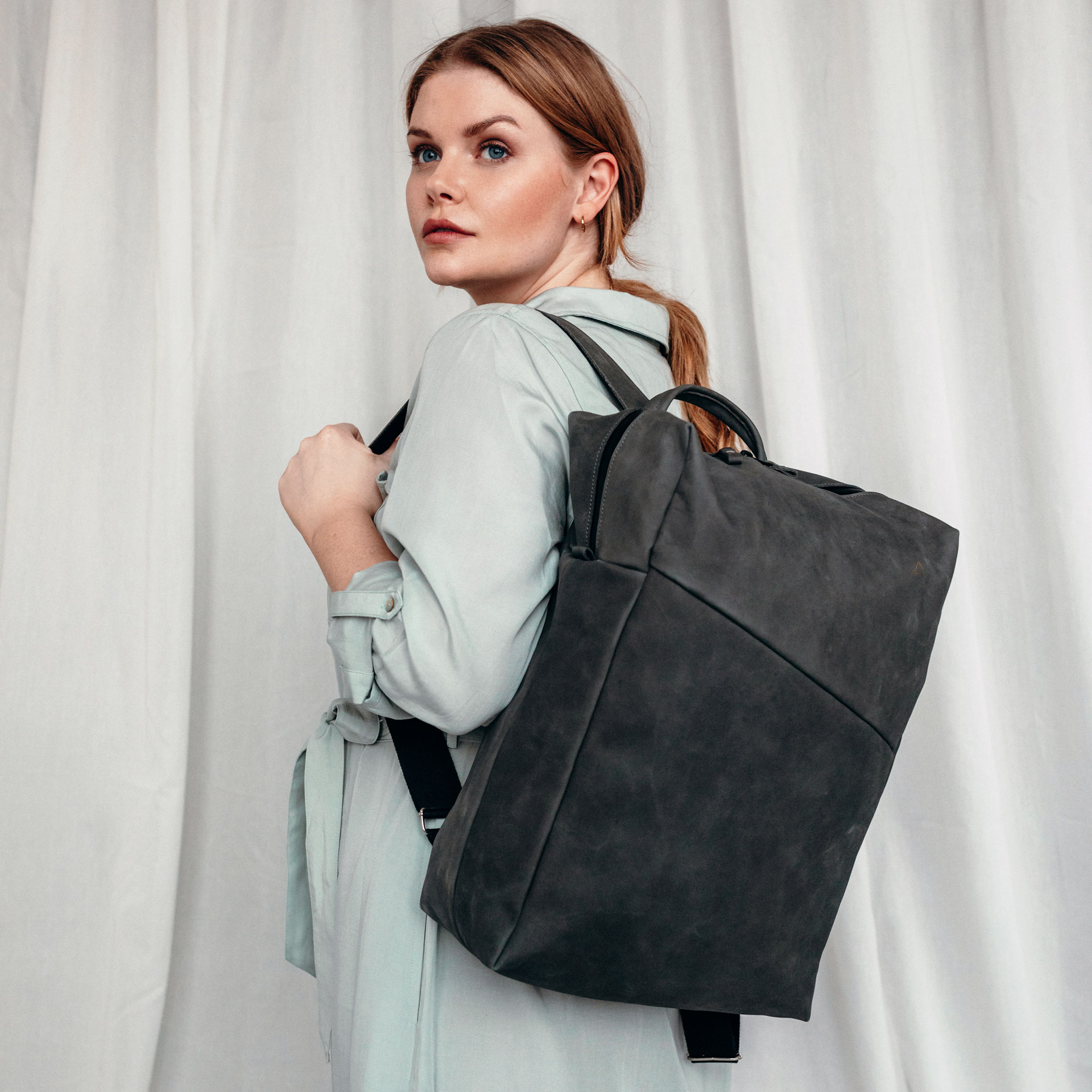 Mpodel tzrägt NEO Large in der Farbe Steingrau auf einer Schulter.