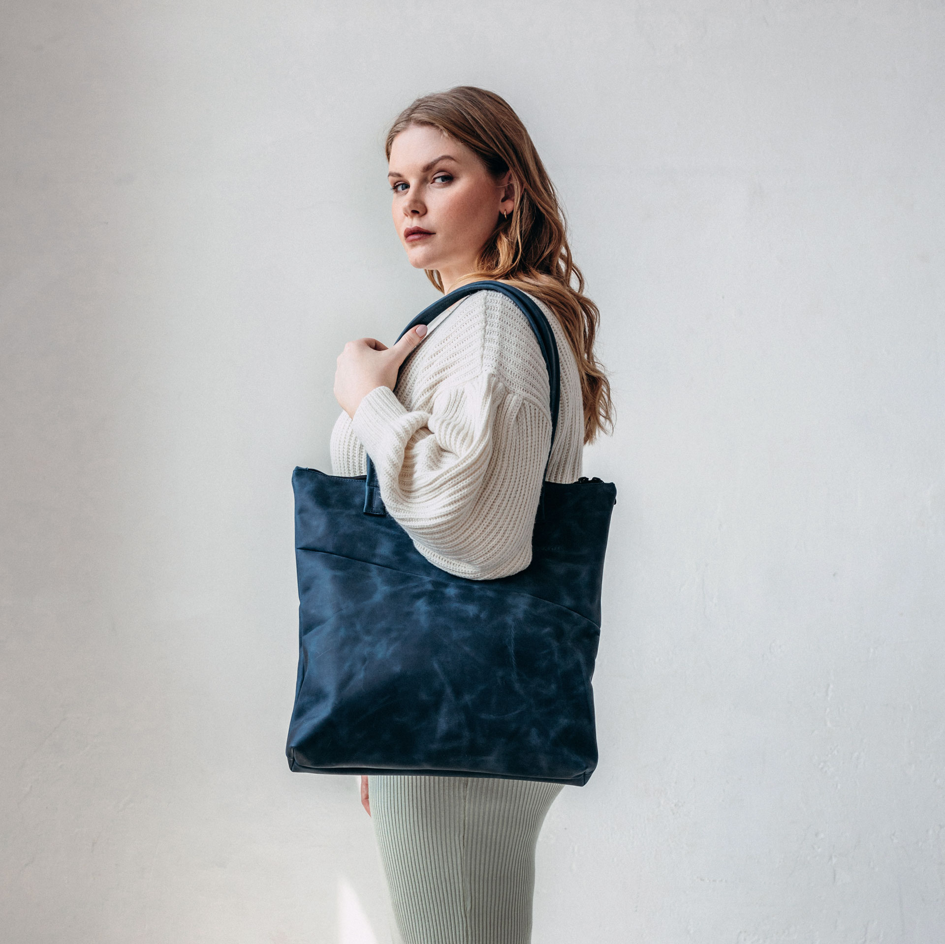 Model trägt Shopper FIA in der Farbe Dunkelblau über der Schulter.