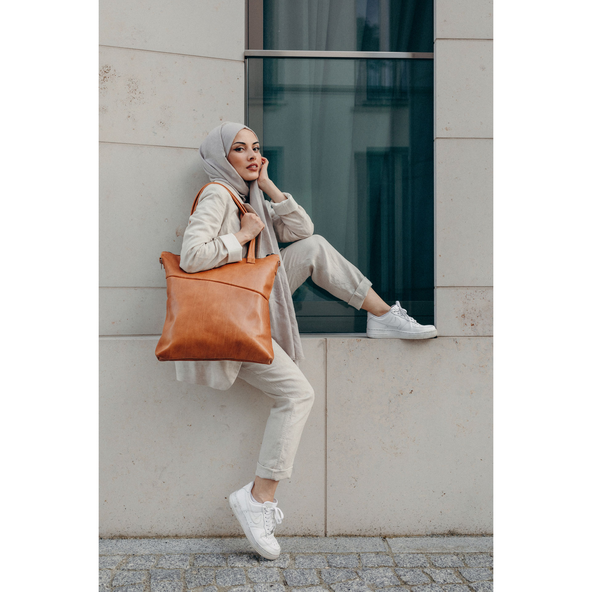 Model trägt Shopper FIA in der Farbe Cognac geölt über der Schulter.