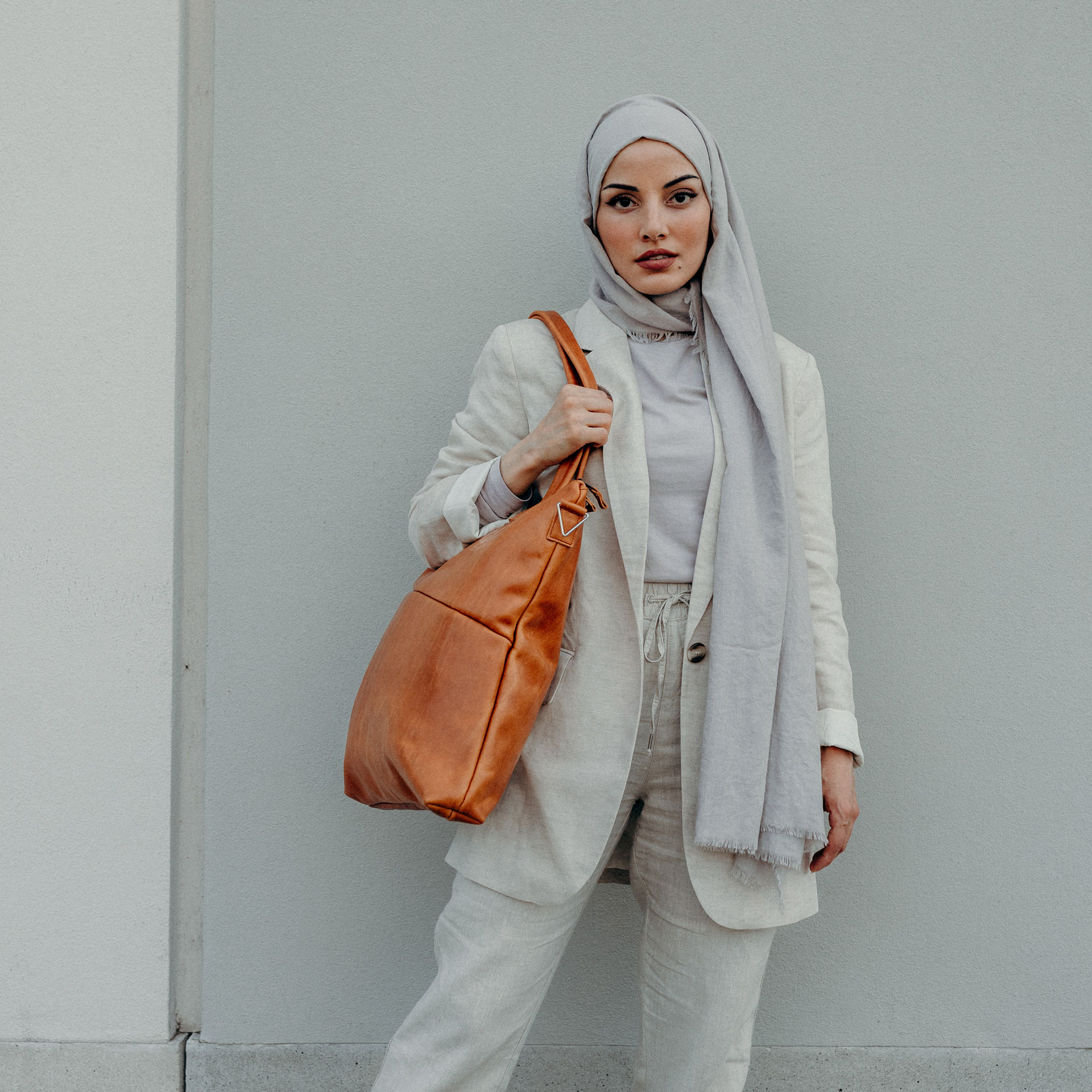 Model trägt Shopper Fia in Cognac geölt aus nachhaltigem Naturleder über der Schulter.