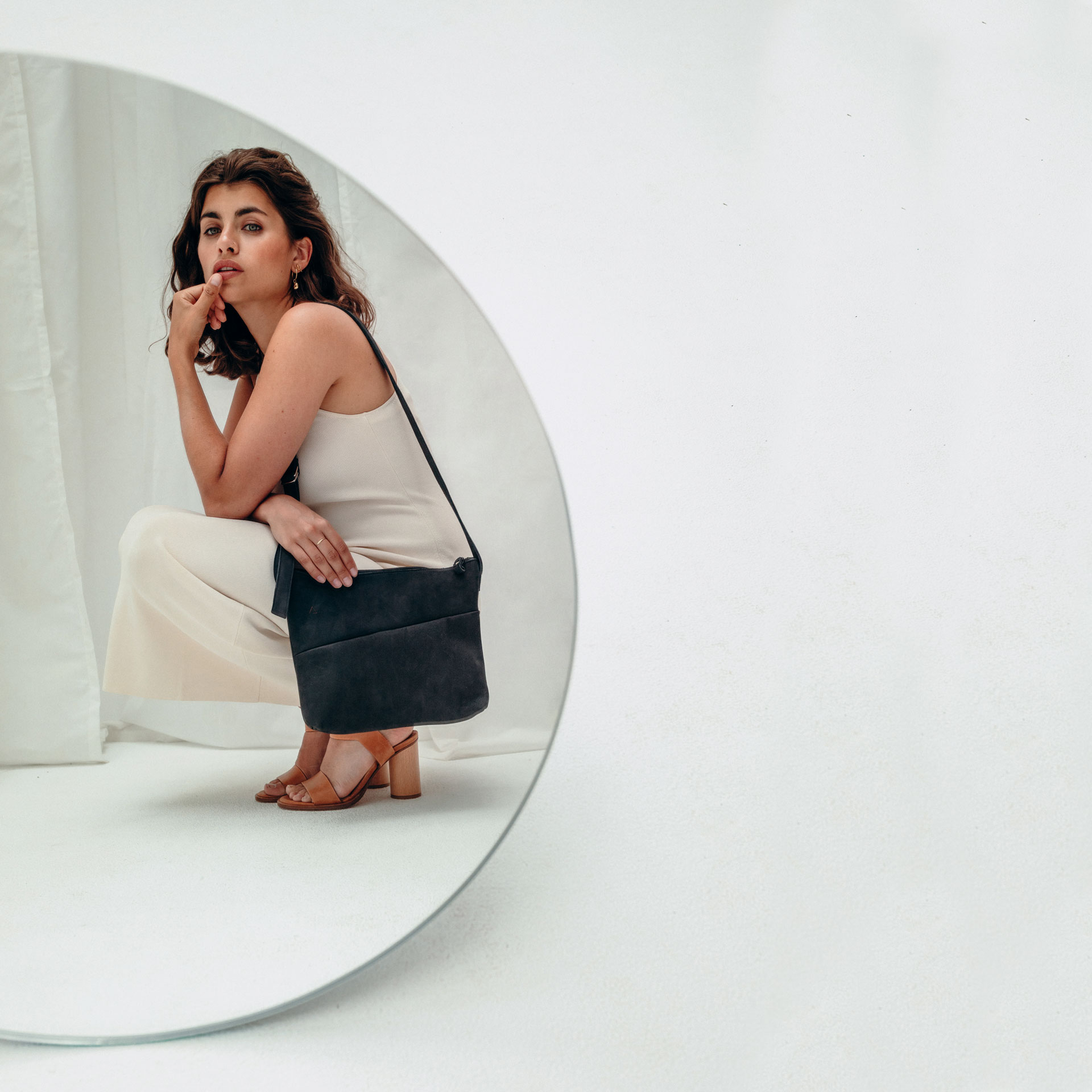 Model mit Umhängetasche Ida aus kohlefarbenem Naturleder