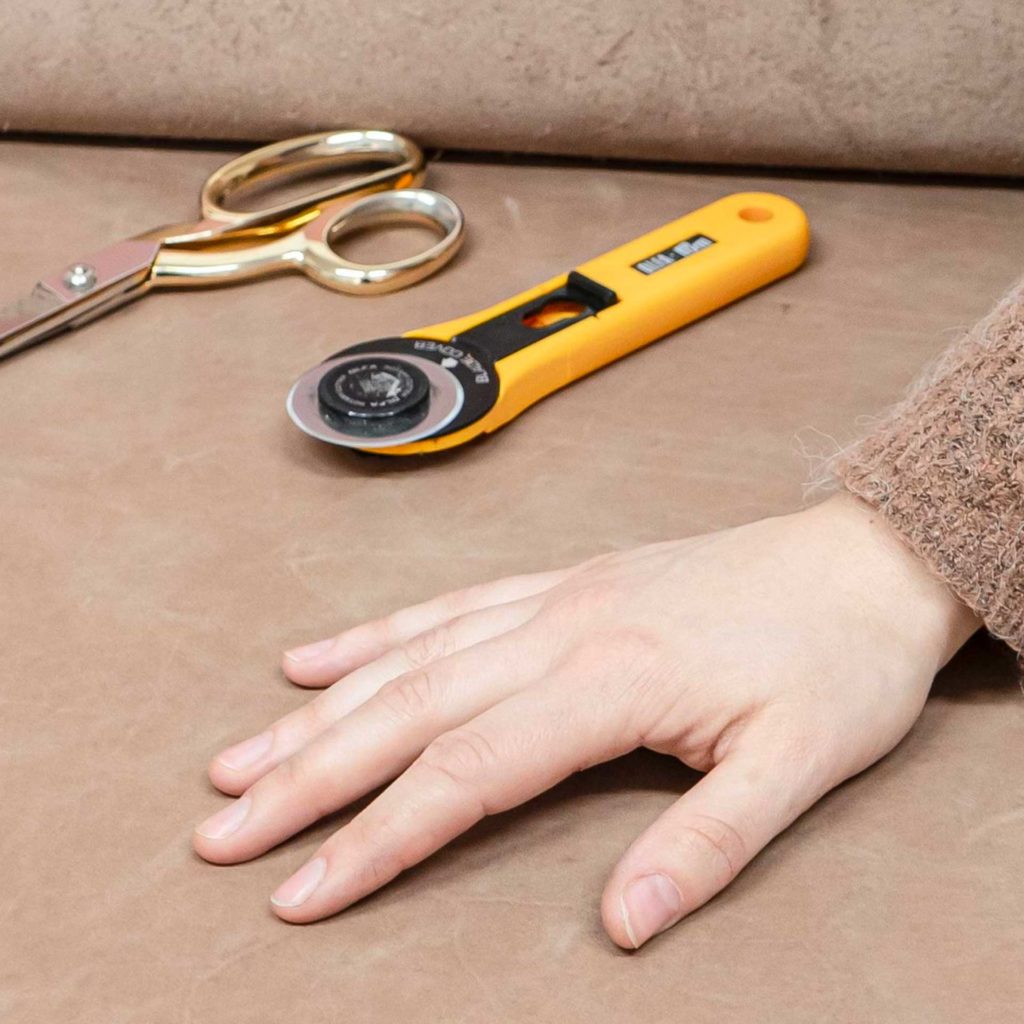 Schere und Cutter auf Haut in Hellbraun