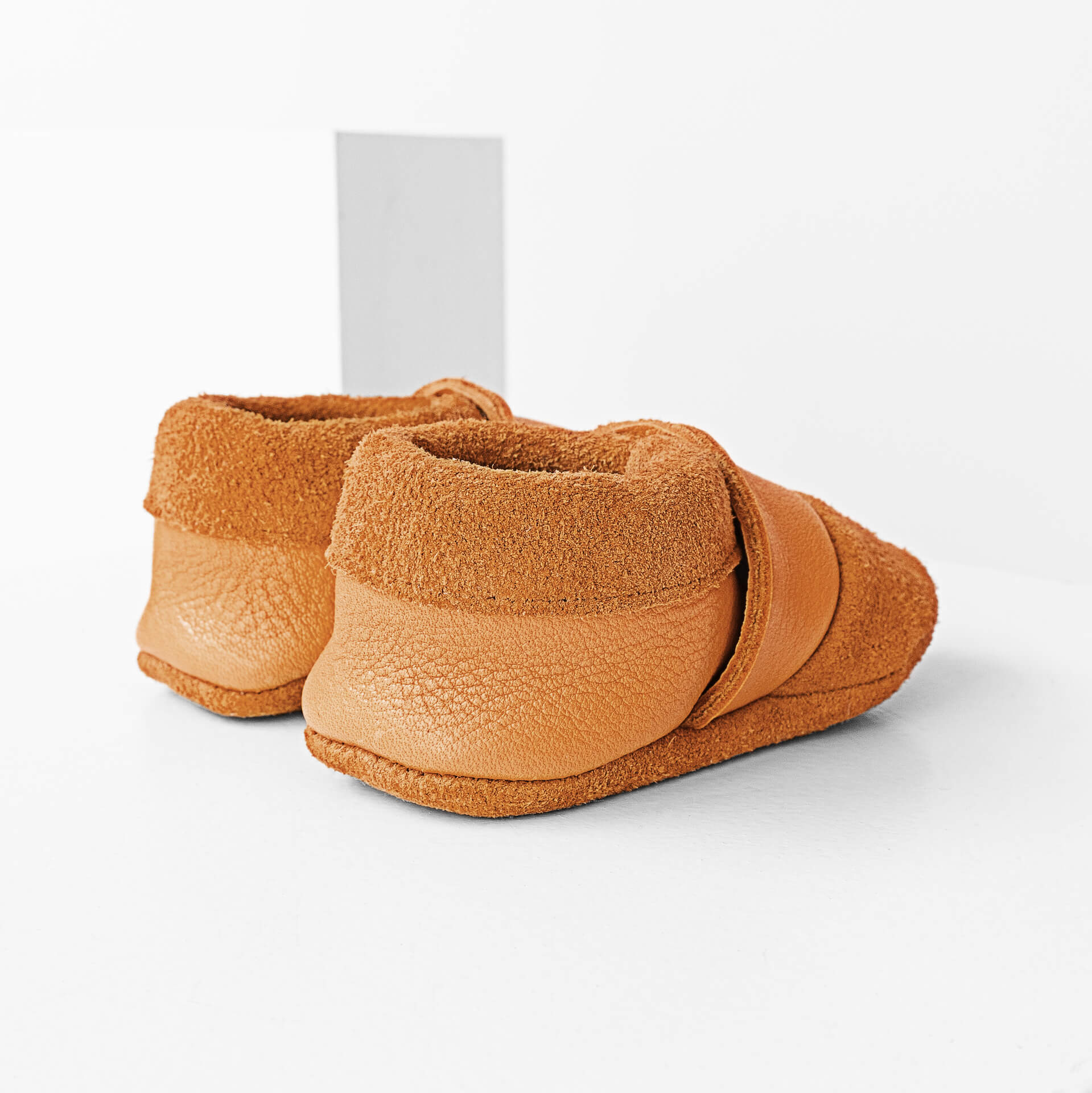 Seitliche Rückansicht der Lauflernschuhe MOQ aus nachhaltigem Naturleder in Cognac