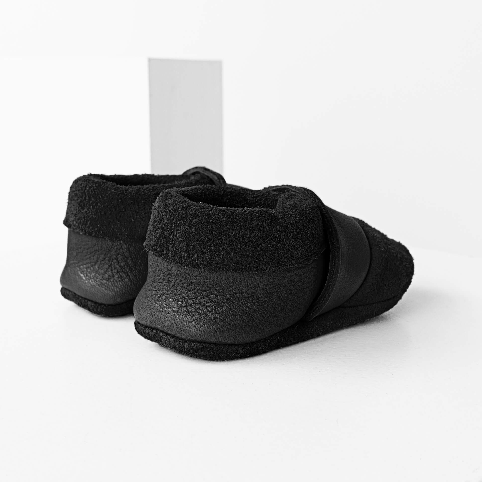 Seitliche Rückansicht der Lauflernschuhe MOQ aus nachhaltigem Naturleder in Schwarz