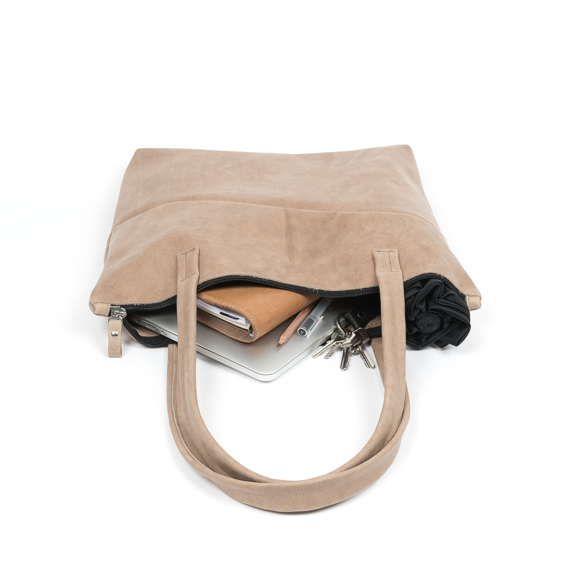 Wickeltasche MIA MIDI aus Naturleder in Hellbraun gepackt mit Laptop, Notizbuch, Regenschirm und Kleinutensilien