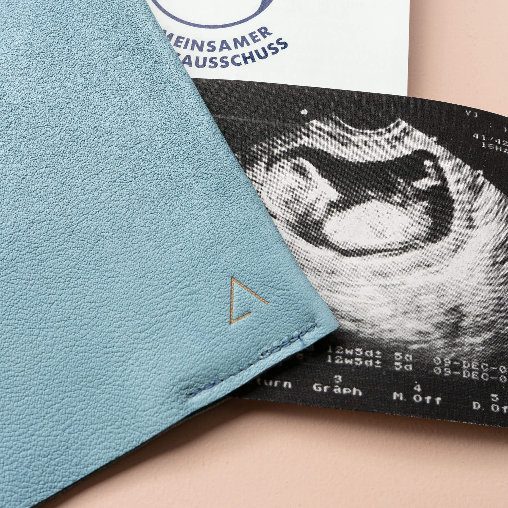 Mood Shot Detailansicht der Logoprägung auf Mutterpasshülle EVE aus Naturleder in Hellblau