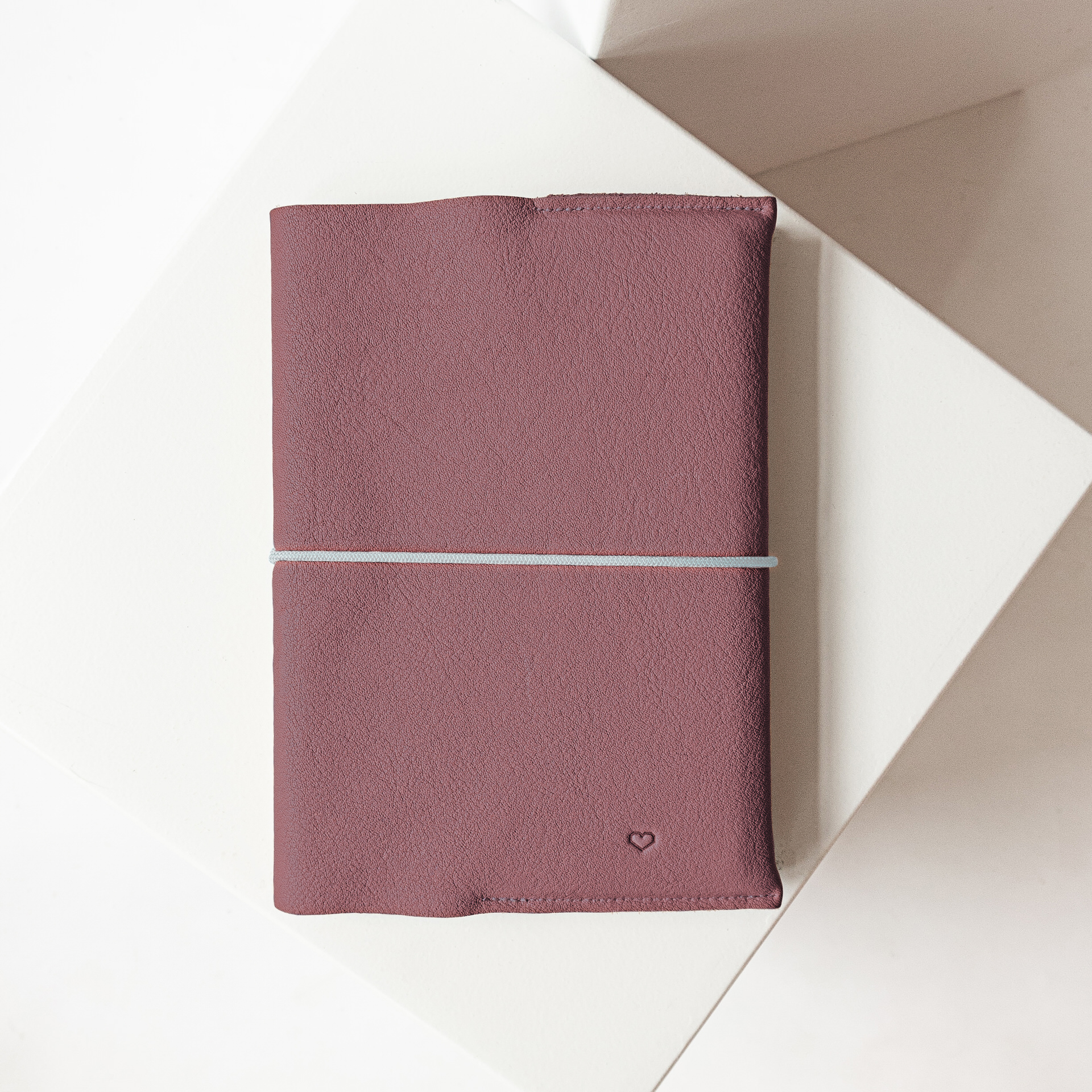 U-Hefthülle EVE aus nachhaltigem Naturleder in Flieder mit schlichter Herz-Prägung und grauem Verschlussband