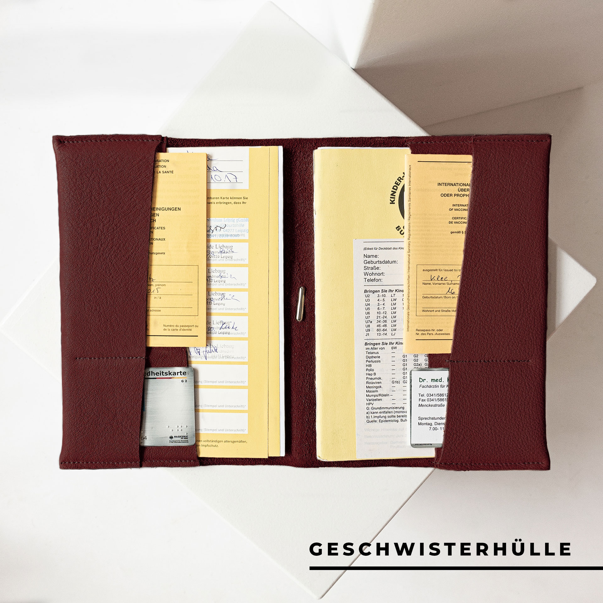 Innenansicht der U-Hefthülle EVE als Geschwisterhülle in Weinrot mit U-Heften, Impfpässen und Versicherungskarten