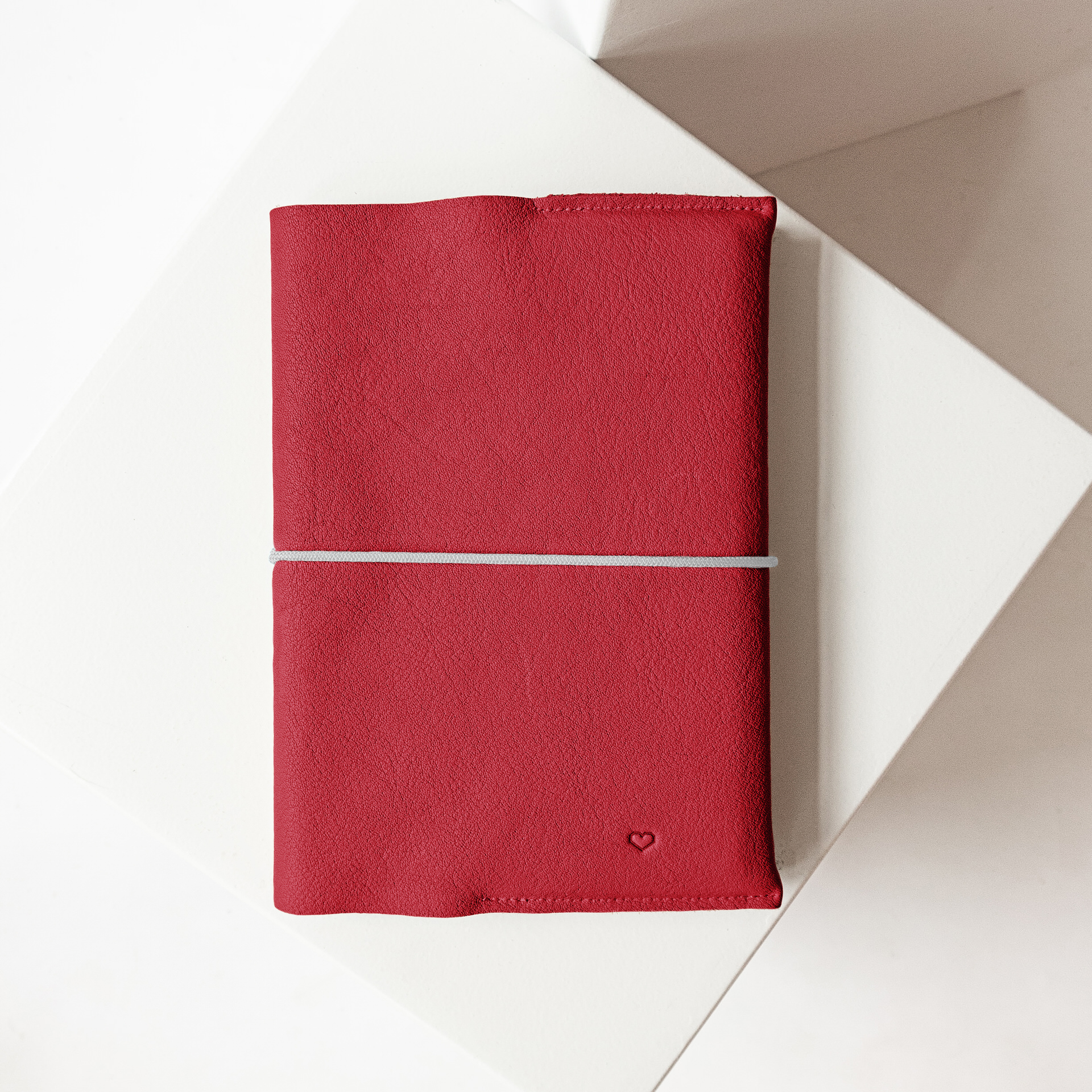 U-Hefthülle EVE aus nachhaltigem Naturleder in Rot mit schlichter Herz-Prägung und grauem Verschlussband